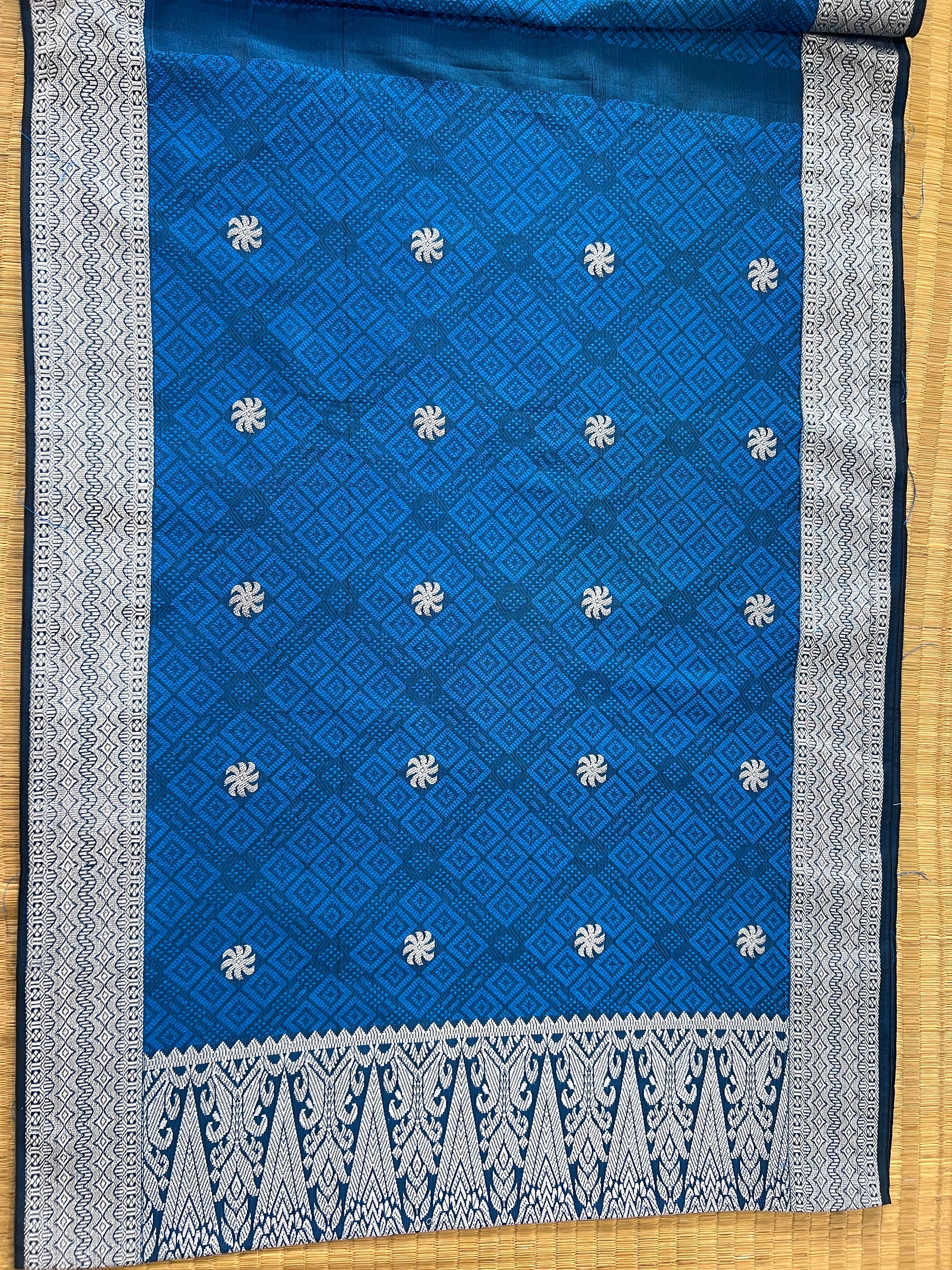 Blue fabric with white floral patterns on a wooden surface